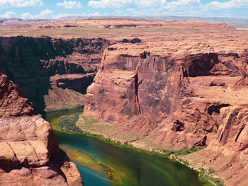 Rock formations by river against sky