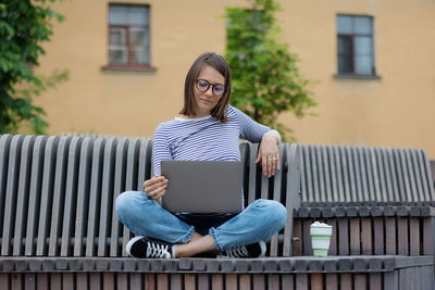 A female blogger with a laptop and a smartphone records content for her subscribers. work online