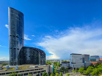 Modern buildings in city against blue sky