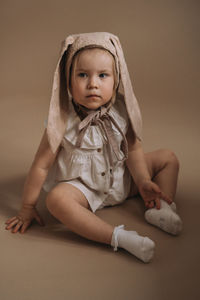 Portrait of cute baby girl sitting at home