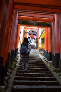 Full length rear view of woman standing on footbridge