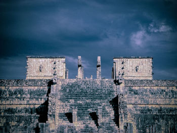 Low angle view of old building against cloudy sky