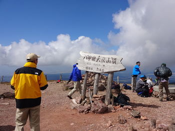 Rear view of people standing on land