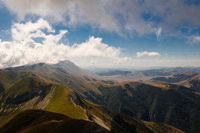 Scenic view of valley and mountains against sky