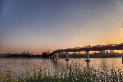 Bridge over river at sunset