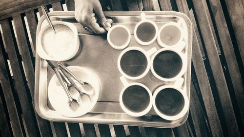 High angle view of hand holding tea cup on table