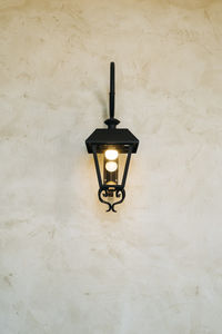 Illuminated light bulb mounted on wall