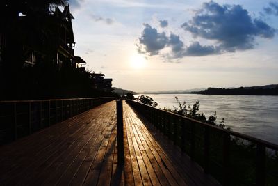 Pier over sea against sky during sunset