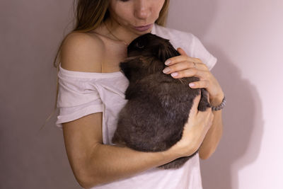 Midsection of woman with dog at home