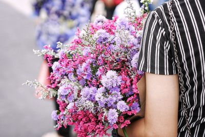 Midsection of woman holding bouquet