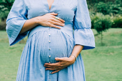 Close up of unrecognizable pregnant woman holding her belly