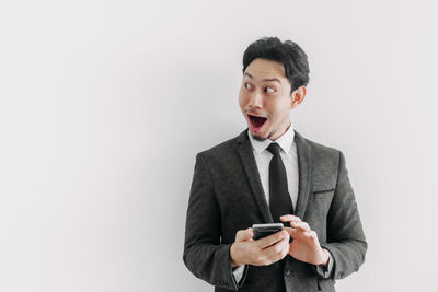 Full length of man using smart phone against white background