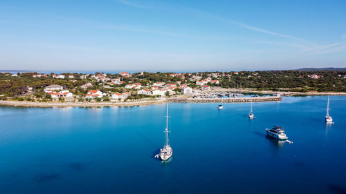 High angle view of sailboats in sea against blue sky