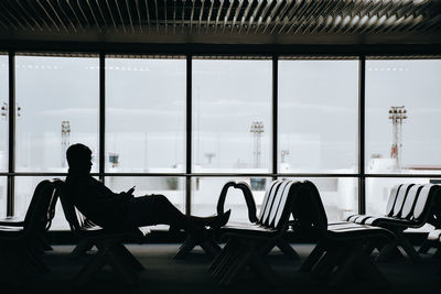 Silhouette woman sitting on table at airport