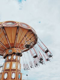 Low angle view of chain swing ride against sky