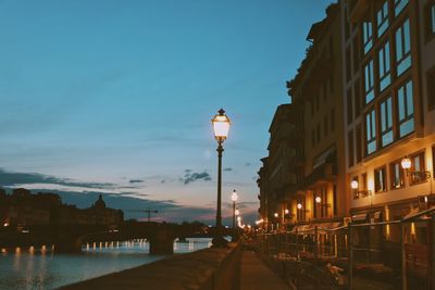 Street amidst buildings against sky at dusk