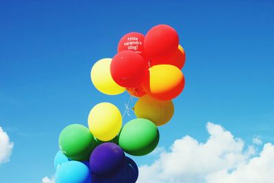 Low angle view of colorful balloons against blue sky