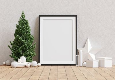 White christmas tree on hardwood floor against wall