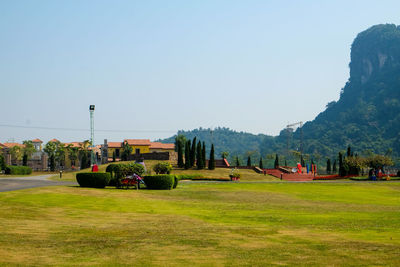 People on landscape against clear sky