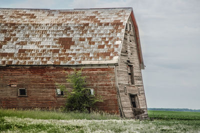 Abandoned house on field against sky