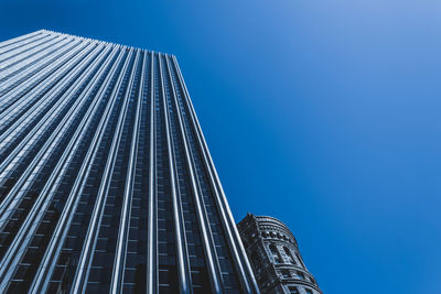 Low angle view of skyscrapers against clear blue sky