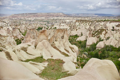 Scenic view of rock formations against cloudy sky
