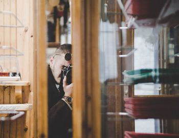 Reflection of man photographing in mirror