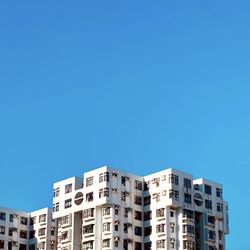 Low angle view of buildings against clear blue sky