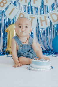 Portrait of cute baby boy sitting on table