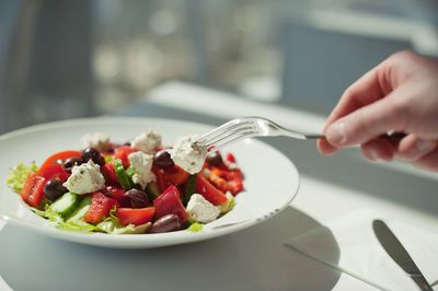 Cropped image of hand holding food on table