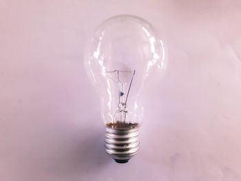 Close-up of light bulb against white background