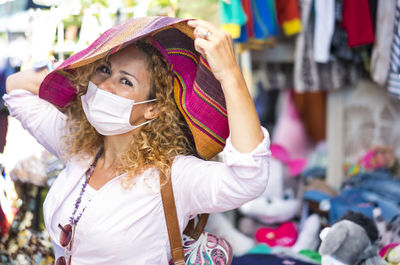 Portrait of woman wearing mask standing in market