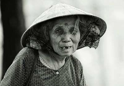 Close-up portrait of senior woman wearing hat standing outdoors
