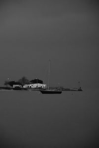 Sailboat in sea against clear sky