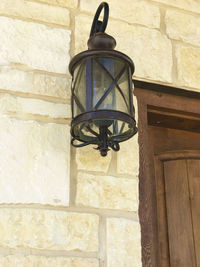 Low angle view of lantern hanging against wall