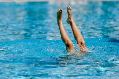 Low section of man swimming in pool