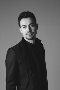 Portrait of young man standing against wall