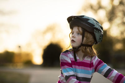 Close-up of girl wearing helmet while looking away