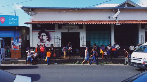 People on street against buildings in city