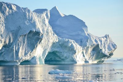 View of majestic iceberg in sea against sky