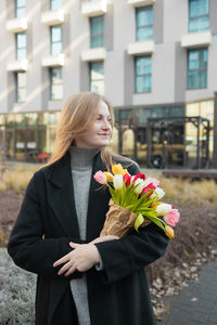Portrait of young woman holding bouquet