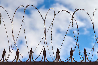 Barbed wire on fence, steel grating fence, metal fence wire. coiled razor wire. safety and security
