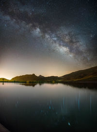 Scenic view of lake against sky at night