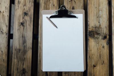 Directly above shot of blank paper on clipboard at table