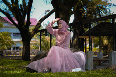 Woman with pink umbrella and plants in park