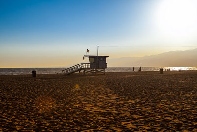 Lifeguard hut at sandy beach against sky