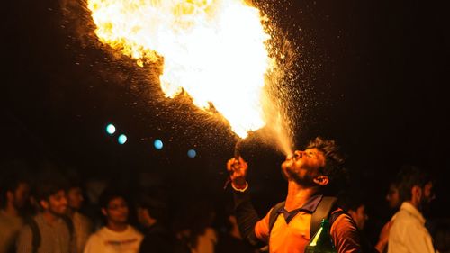 Crowd at music concert against sky at night