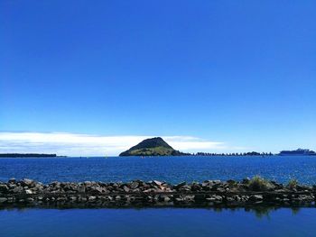 Scenic view of sea against clear blue sky