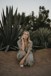 Portrait of woman sitting against plants