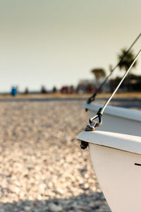 Close-up of ship moored on beach against clear sky